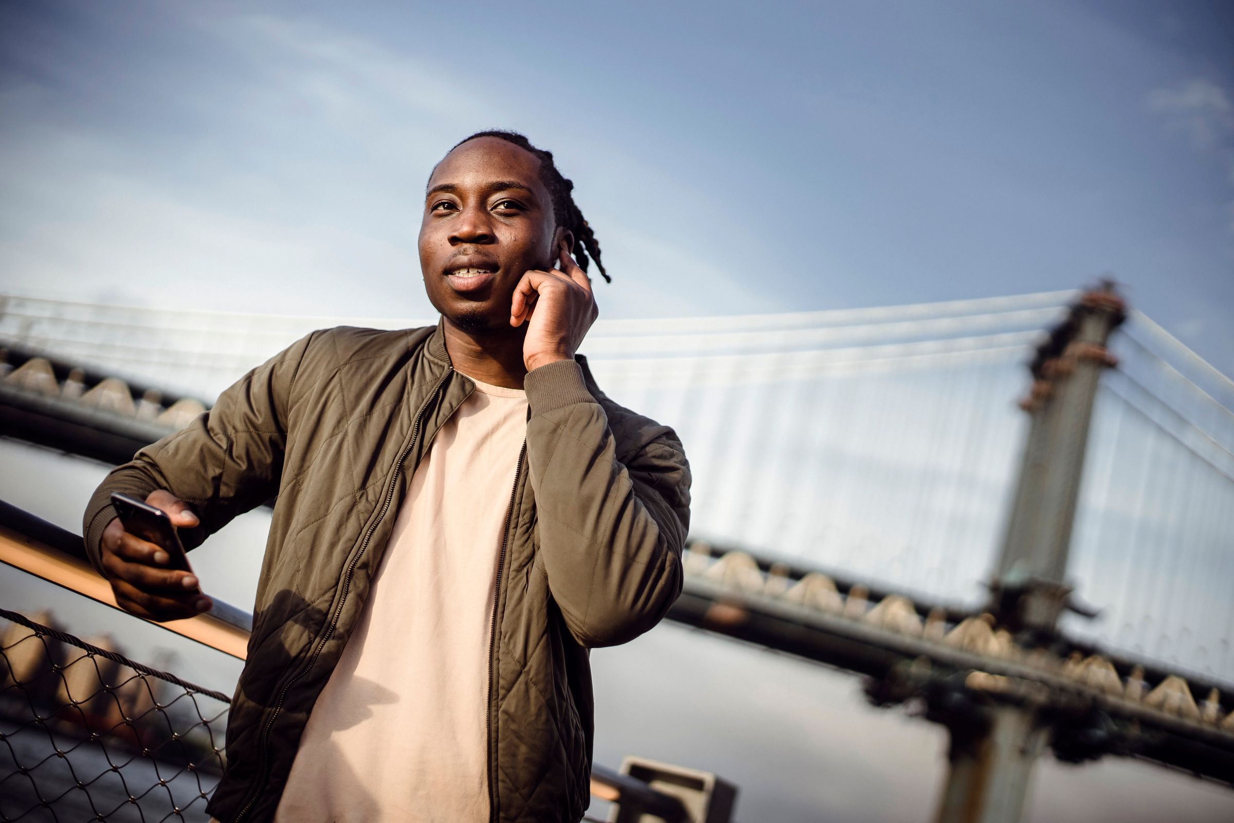 A young man on a phone call outdoors in the city