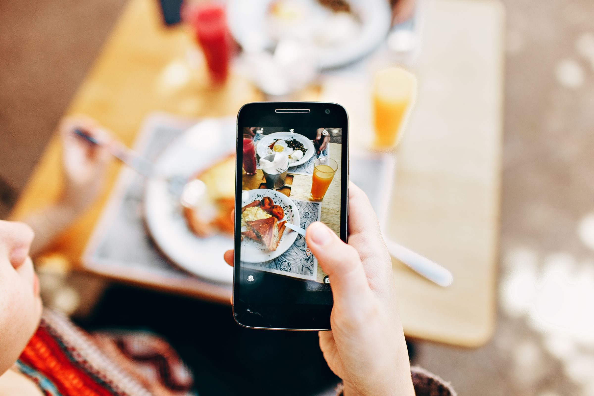 A phone camera held over the plates on a dinner table